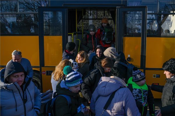 Tiszabecs, 2022. február 28. Az orosz-ukrán háború elől menekülő emberek leszállnak a buszról, amellyel a helyi határátkelőhelytől szállították őket a tiszabecsi II. Rákóczi Ferenc Általános Iskolához 2022. február 28-án. Az intézmény tornaterméből ideiglenes szálláshelyet alakítottak ki a menekültek számára. MTI/Czeglédi Zsolt